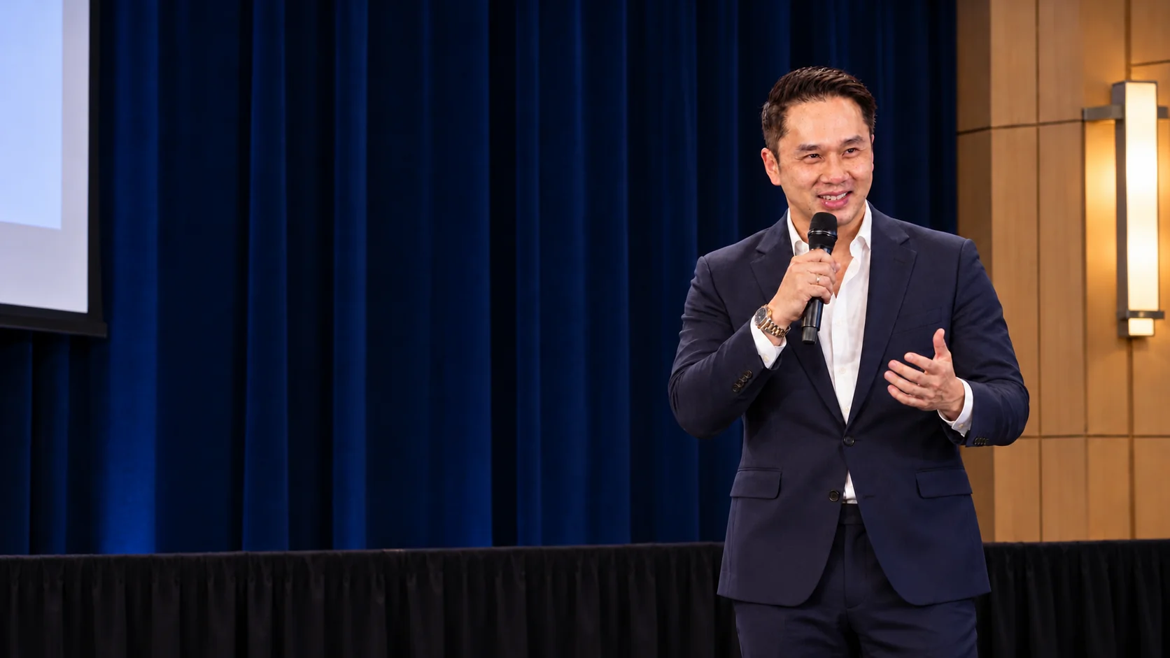 AI generated illustration of Adrian speaking on stage with a microphone