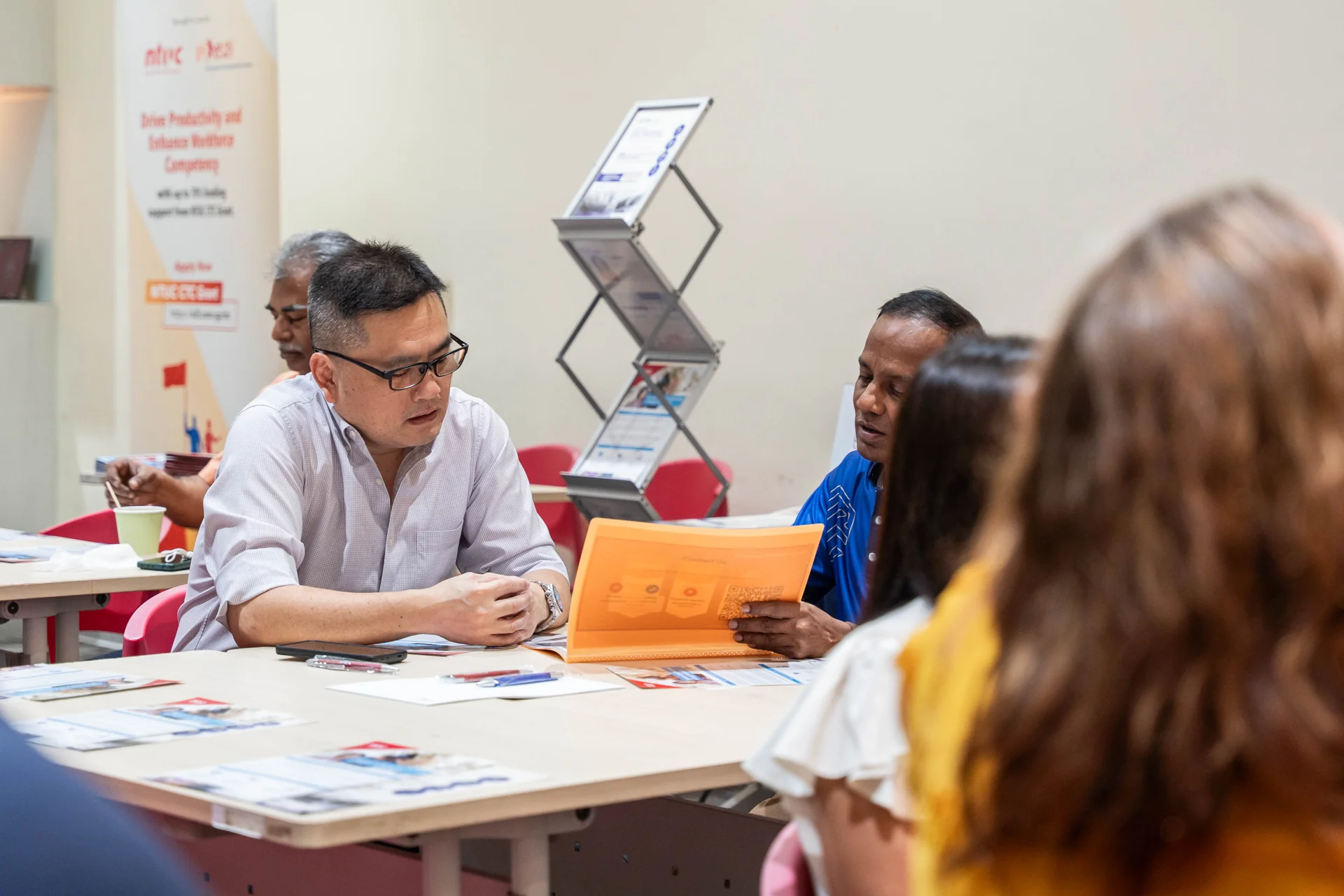 Small group discussing activity materials around a table at a BELLS event