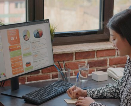 Person writing on sticky notes to remember task on computer