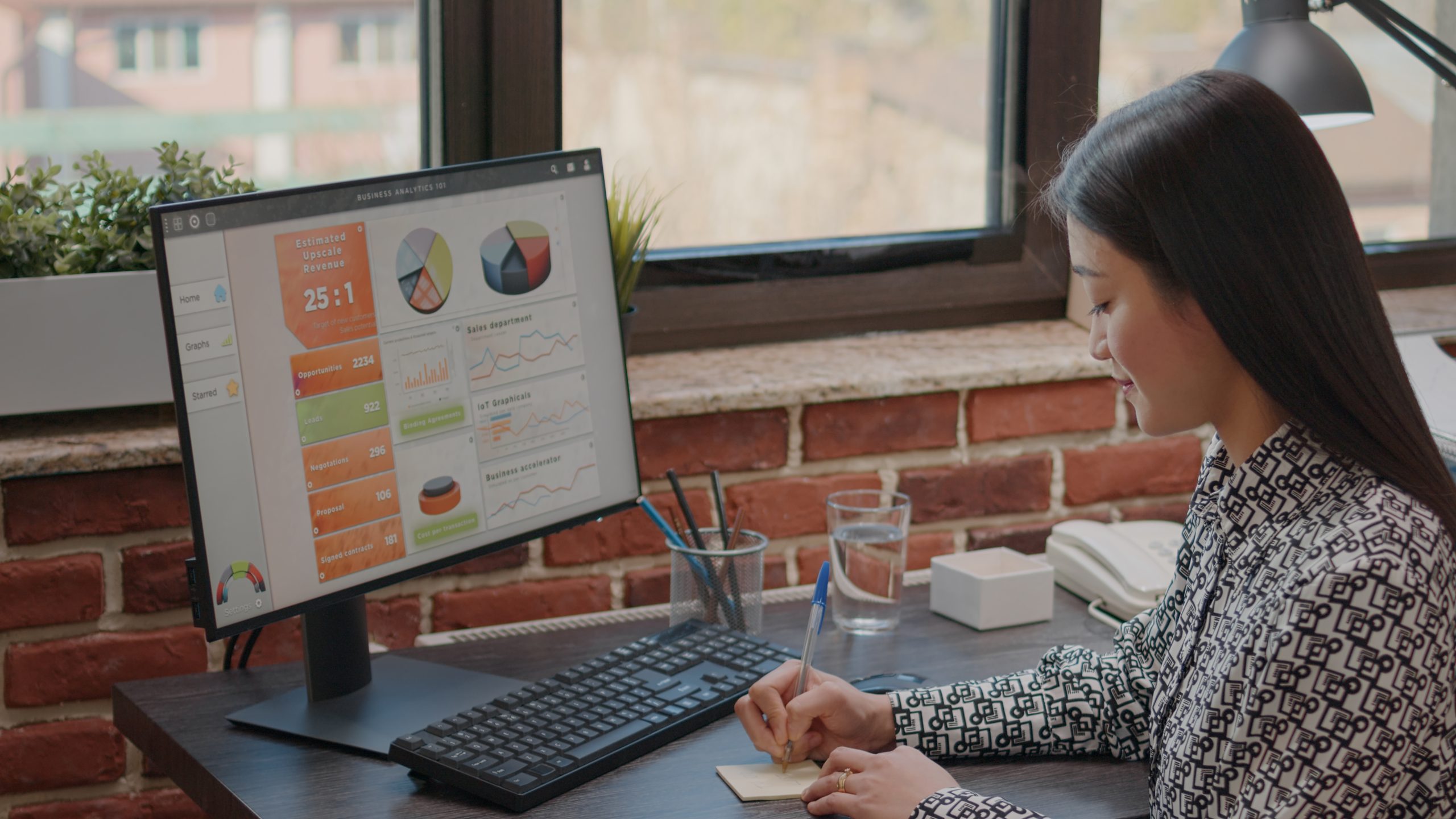 Person writing on sticky notes to remember task on computer